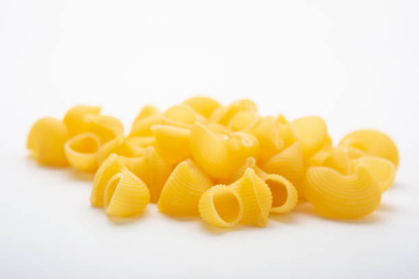 istock Striped sea shell shaped pasta isolated on white background 1221438286