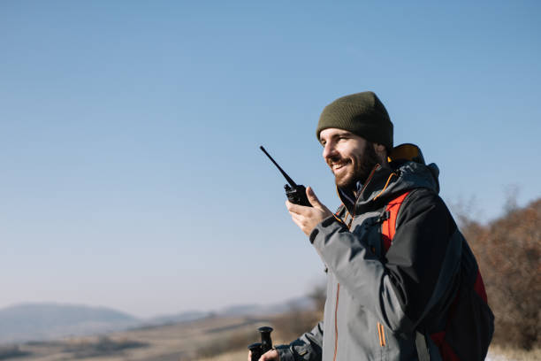 istock Smiling man speaking on two-way radio for hiking 1221438386