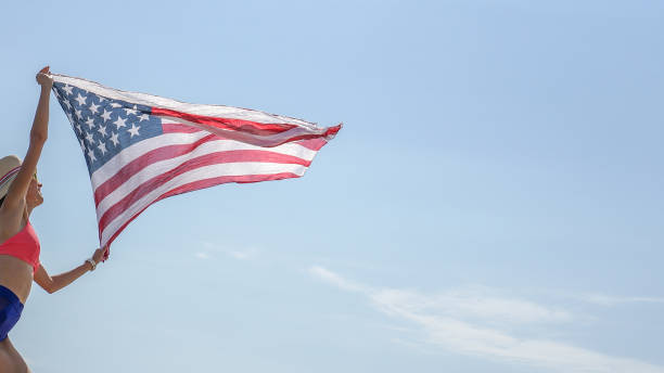 istock Young woman waving with american flag 1221439165