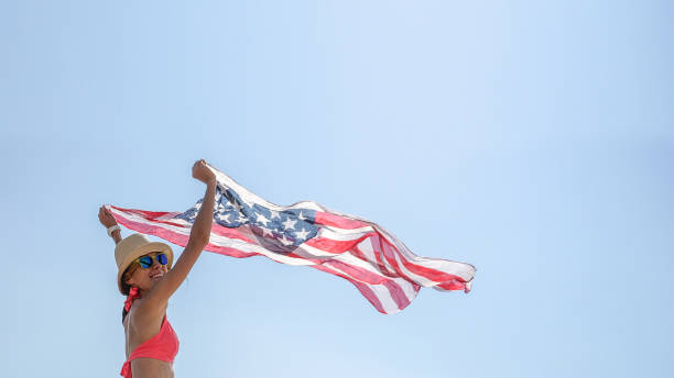 istock Young woman waving with american flag 1221439170
