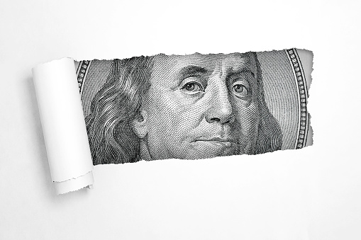 Benjamin Franklin on a Hundred Dollar Bill in the Hole of Torn White Paper extreme closeup. 3d Rendering