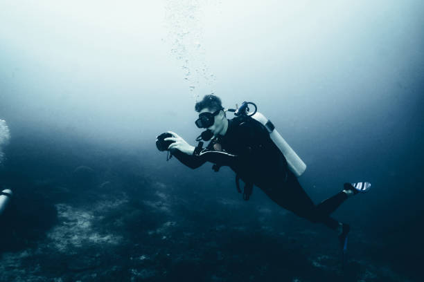 Scuba diver takes underwater photo Bubbles come up from his air tank underwater camera stock pictures, royalty-free photos & images