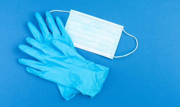 istock Medical gloves and mask on blue background. 1221441501