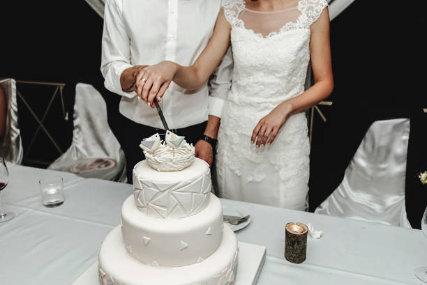 istock Stylish gorgeous bride and elegant groom cutting and tasting  unusual white wedding cake 1221443143