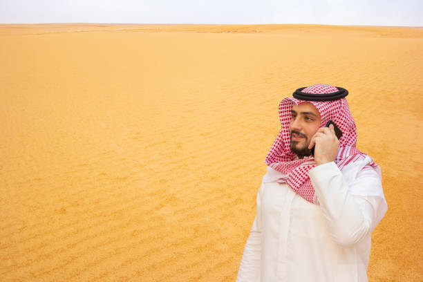 istock An Arabian man using a cellphone on desert background. 1221444483