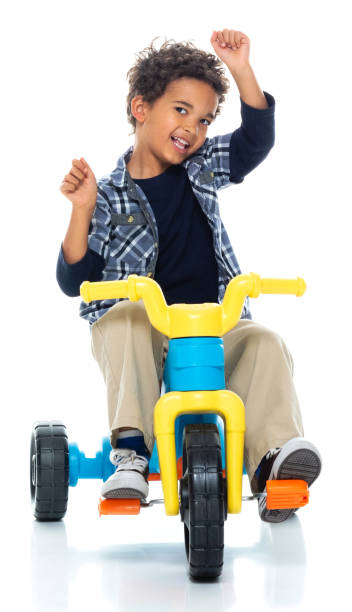 Front view of boys in front of white background who is happy and using bicycle