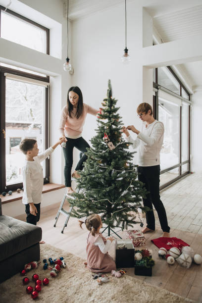 istock New Year. Decorate the Christmas tree. Artificial tree. A girl i 1221446414