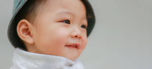 Close-up of Asian adorable toddler kid in good mood smiling happily and relaxed with copy space. Baby care and childhood concept.