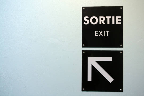 istock Exit sign on a wall painted orange. Underground parking. Saint-Gervais Haute-Savoie. Auvergne-Rhône-Alpes. France. 1221448475
