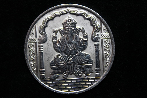 Lord Ganesha on silver coin with black background