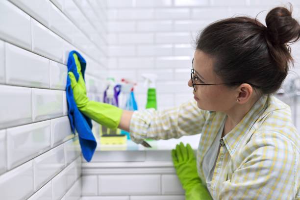 istock Female polishing tiled wall in bathroom with microfiber cloth 1221452800