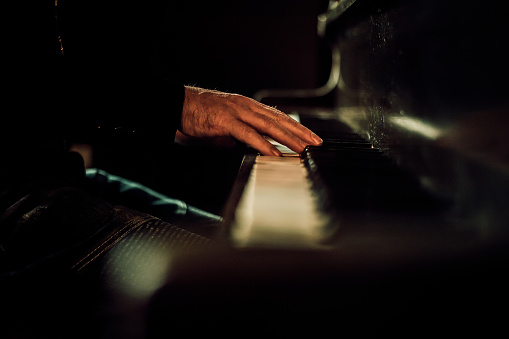 Musician playing a piano with their hands