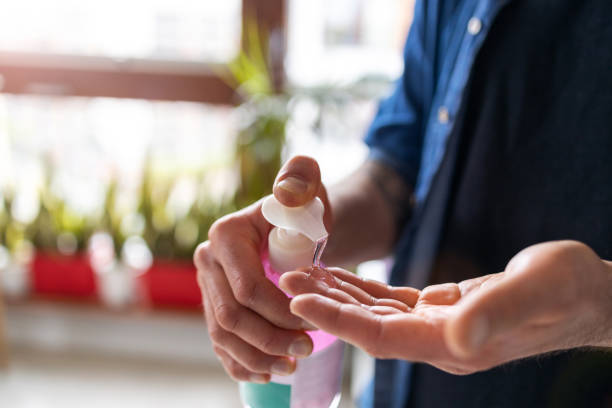 man using hand sanitizer - lubrication infection imagens e fotografias de stock