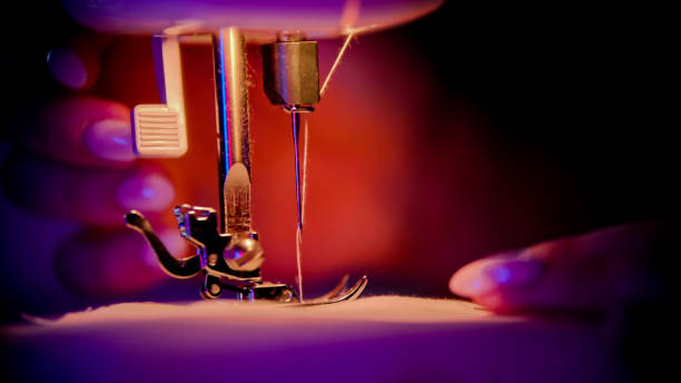 Close up of sewing machine foot and fabric while sewing at home