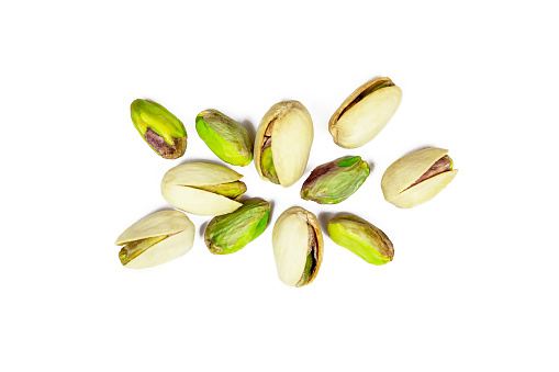 Top view of roasted salted pistachio nuts in nutshell isolated on white background.