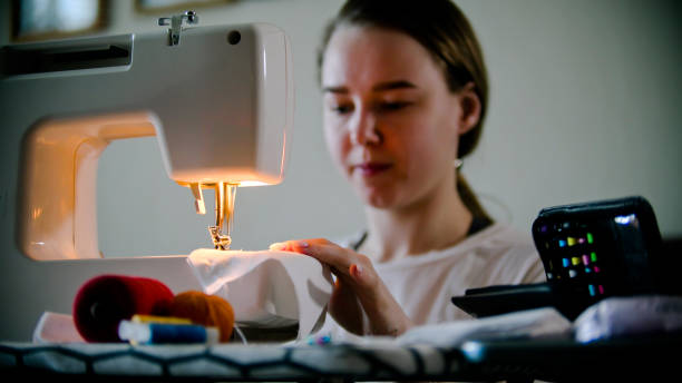 istock Young woman sewing a mask using a sewing machine 1221456719