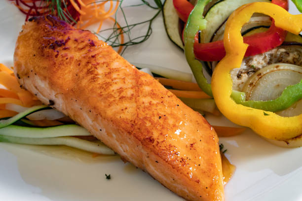 istock Salmon fillet with vegetables on a white plate 1221457161