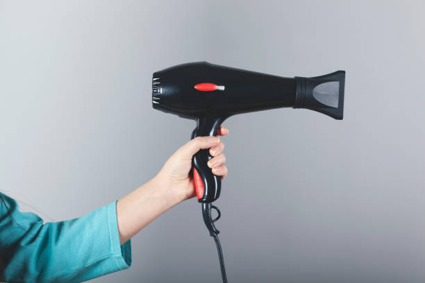 istock woman hand  hair dryer 1221458185