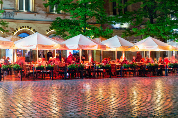 Krakow, Poland - May 15, 2019: Evening view with rain and people sitting at terraces at main market square Krakow, Poland