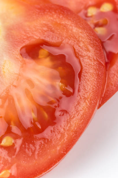 istock Macro closeup sliced tomato over white background copy space 1221461622