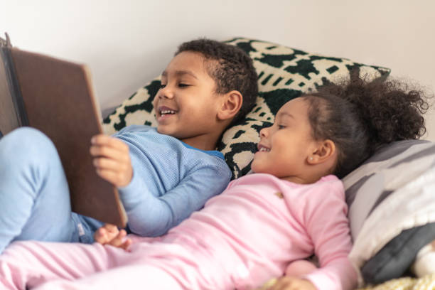 istock Cute moment between siblings reading a book together 1221462301