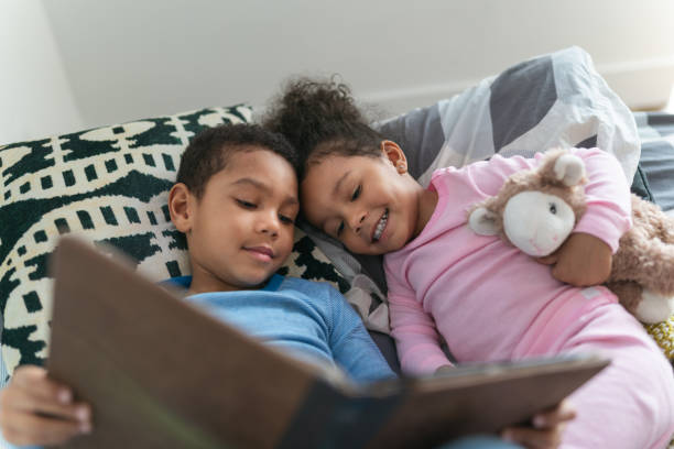 istock Cute moment between siblings reading a book together 1221462303