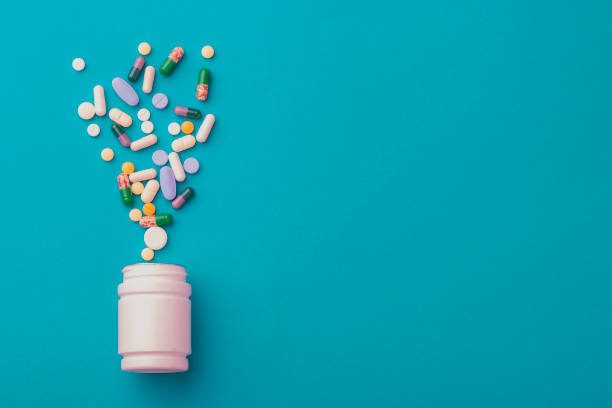 istock Assorted pharmaceutical medicine pills, tablets and capsules and bottle on green background. Copy space for text 1221462726