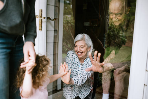 la bambina visita i nonni attraverso la finestra - grandmother child grandparent isolated foto e immagini stock