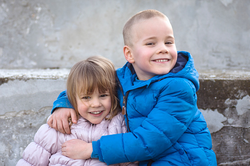 The little sister and the big brother are together, cute smiling children.