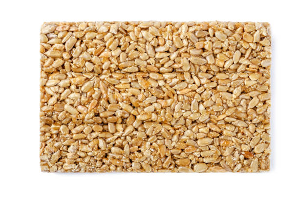 istock Sunflower seeds in caramel Isolated on white background 1221467305