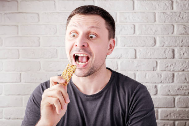 istock man bites yellow granola bar 1221467309