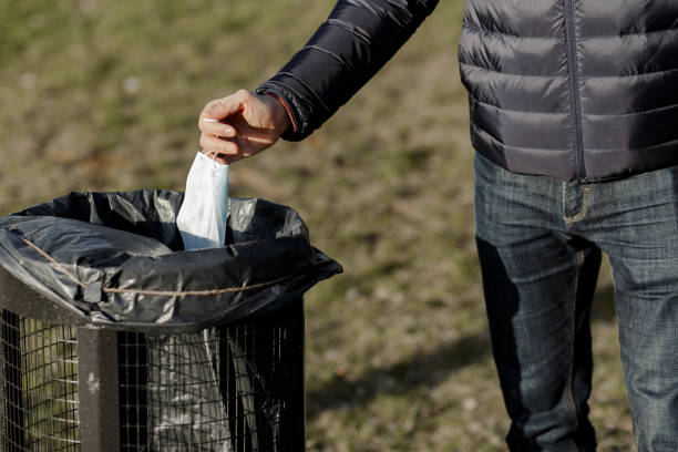 istock guy throw a disposable mask in the trash. 1221467632