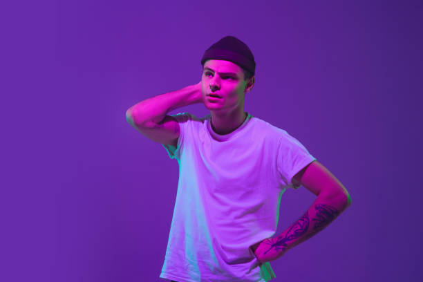 istock Caucasian man's portrait isolated on purple studio background in neon light 1221468291