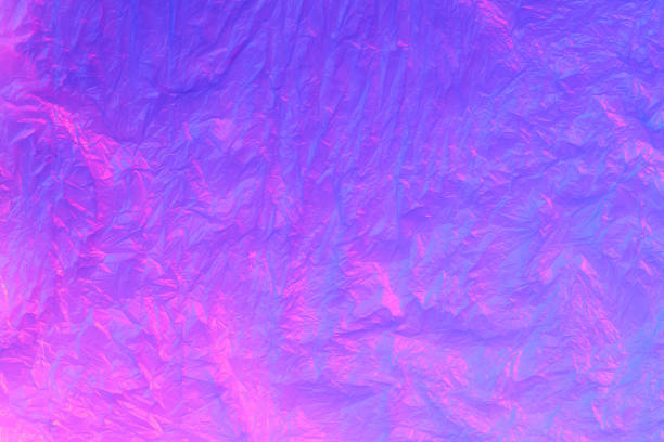 istock Background from purple recyclable polyethylene in neon pink light. Eco, zero waste, alternative to plastic concept. Flat lay. Horizontal. Closeup 1221468487