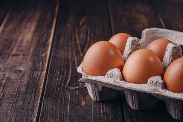istock Raw chicken eggs in a package on a wooden background. Copy space. Space for text 1221469092