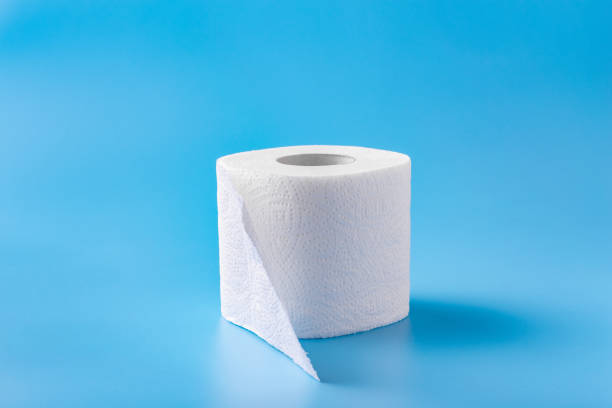 A roll of toilet paper on a blue background. Copy space. Space for text.