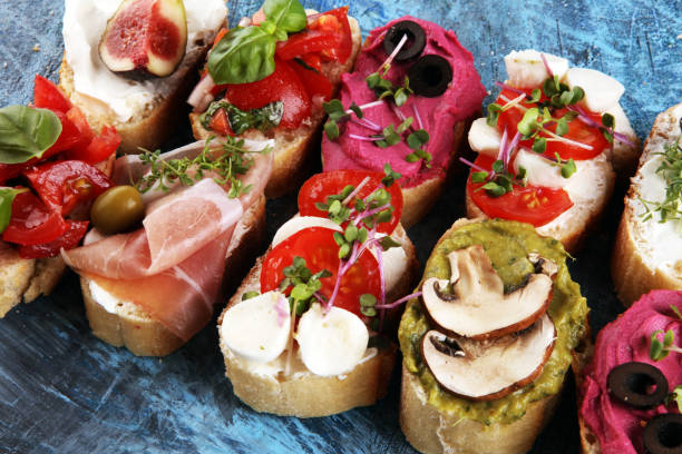 istock Assorted bruschetta with various toppings. Appetizing bruschetta or crudo crostini. Variety of small sandwiches. Mix bruschetta with tomatoes and basil 1221470396