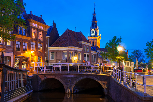 Bridge over a canal Mient in the historical center of Alkmaar, Netherlands, during twilight. The tower in the background is the Waag.
