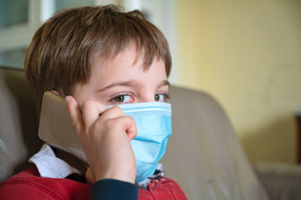 istock Boy with mask at home 1221471480
