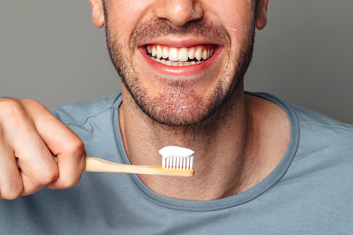 Oral hygiene: mouth of a man ready to brush his teeth.