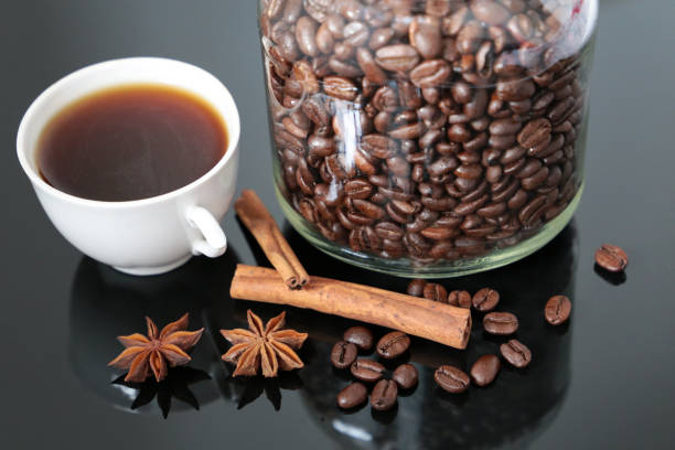 istock Coffee with spices, dark roasted coffee beans in glass jar 1221473681