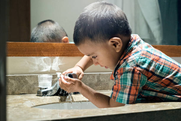istock 5 year old boy washes his hands in the bathroom at home 1221473977