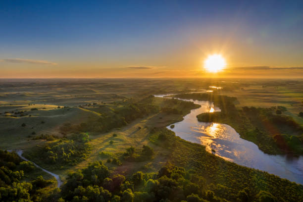 sunrise over Dismal River in Nebraska Sandhills sunrise over Dismal River meandering through Nebraska Sandhills at Nebraska National Forest, aerial view of summer scenery grassland in morning sunrise stock pictures, royalty-free photos & images