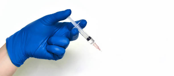 istock Person in gloves hold vaccine syringe 1221476408
