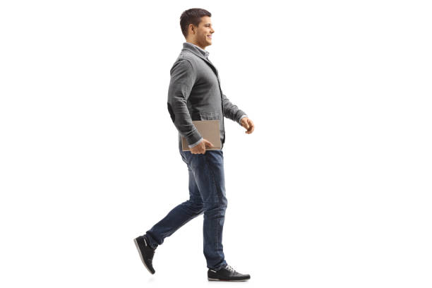 istock Man holding a book and walking 1221476635