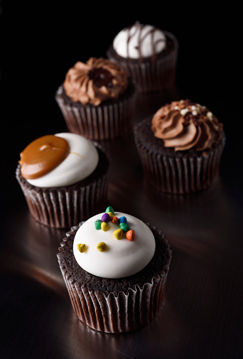 Chocolate cupcakes with cream cheese, sweet candy eggs shaped. Holiday homemade dessert. Copy space.