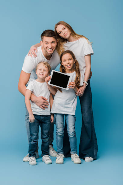 istock happy family showing digital tablet with blank screen on blue 1221478657