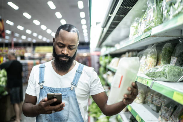 istock Man buying at supermarket using mobile phone 1221479483