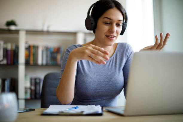 young woman having video call on laptop computer at home - online university imagens e fotografias de stock