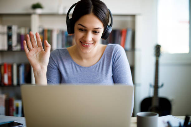 istock Young smiling woman having video call on laptop computer at home 1221479537